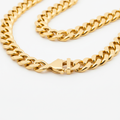 Men's gold Cuban link chain necklace on white background